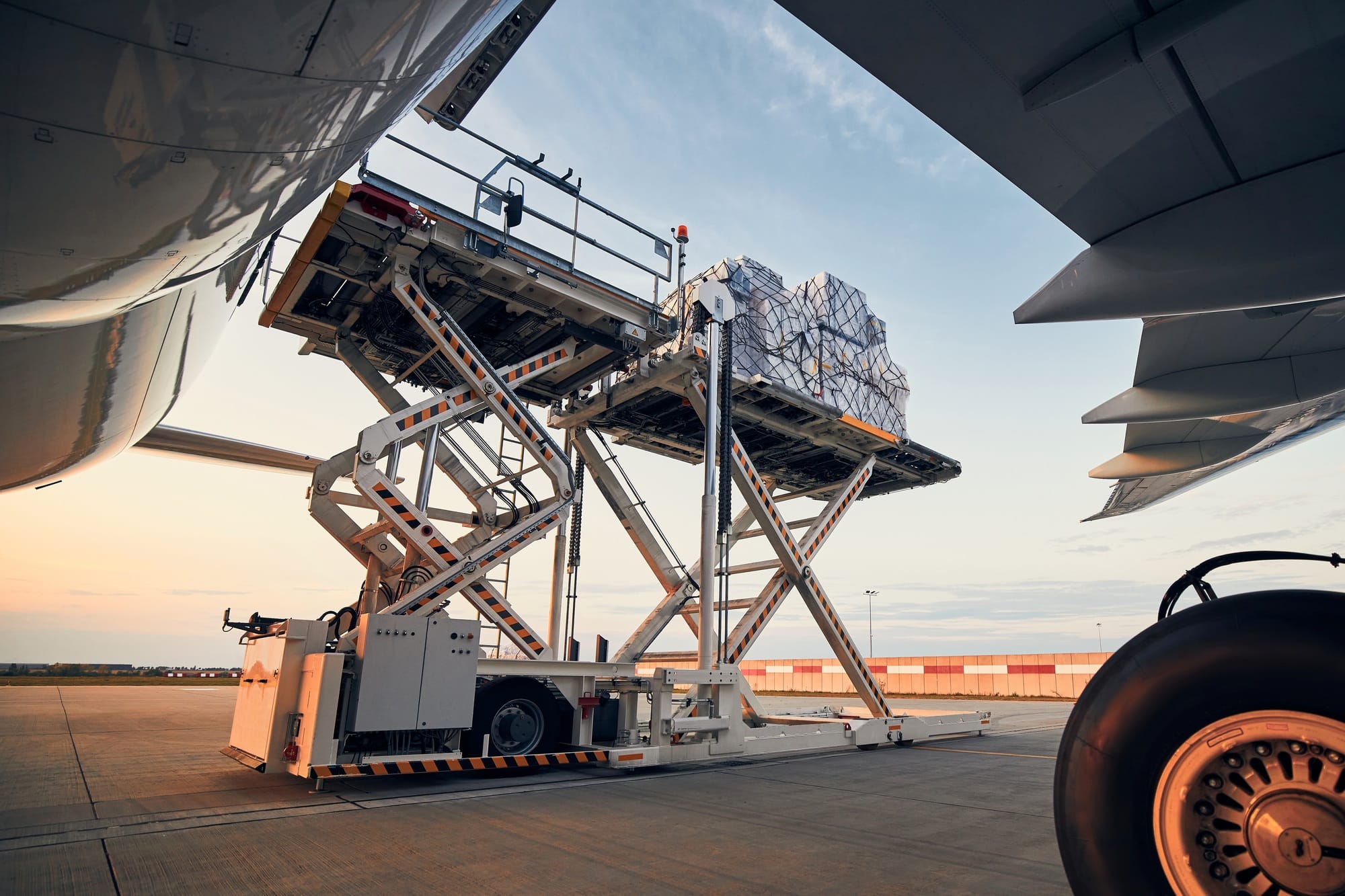 Preparation before flight. Loading of cargo containers to airplane at airport.